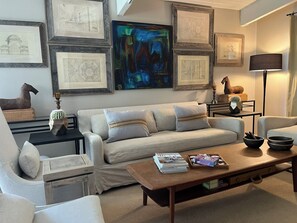 A living room with a sofa, coffee table, and framed artwork on the wall.