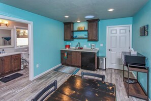 Una cocina con armarios de madera, un refrigerador y una mesa de comedor con sillas.