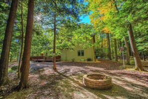 Una cabaña rodeada de altos árboles en un bosque.