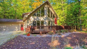 A cabin with a porch, surrounded by a forest. - Dog-Friendly, Secluded Cabin in the Woods (Egg Harbor)