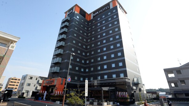A multi-story hotel with a modern design, featuring a prominent 'APHA HOTEL' sign at the top. - APA Hotel Tsukuba-Bampakukinenkoen-Ekimae (Tsukuba)