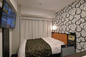 A hotel room with a bed, a television on the wall, a headboard with a control panel, and a patterned wall. - APA Hotel Tsukuba-Bampakukinenkoen-Ekimae (Tsukuba)