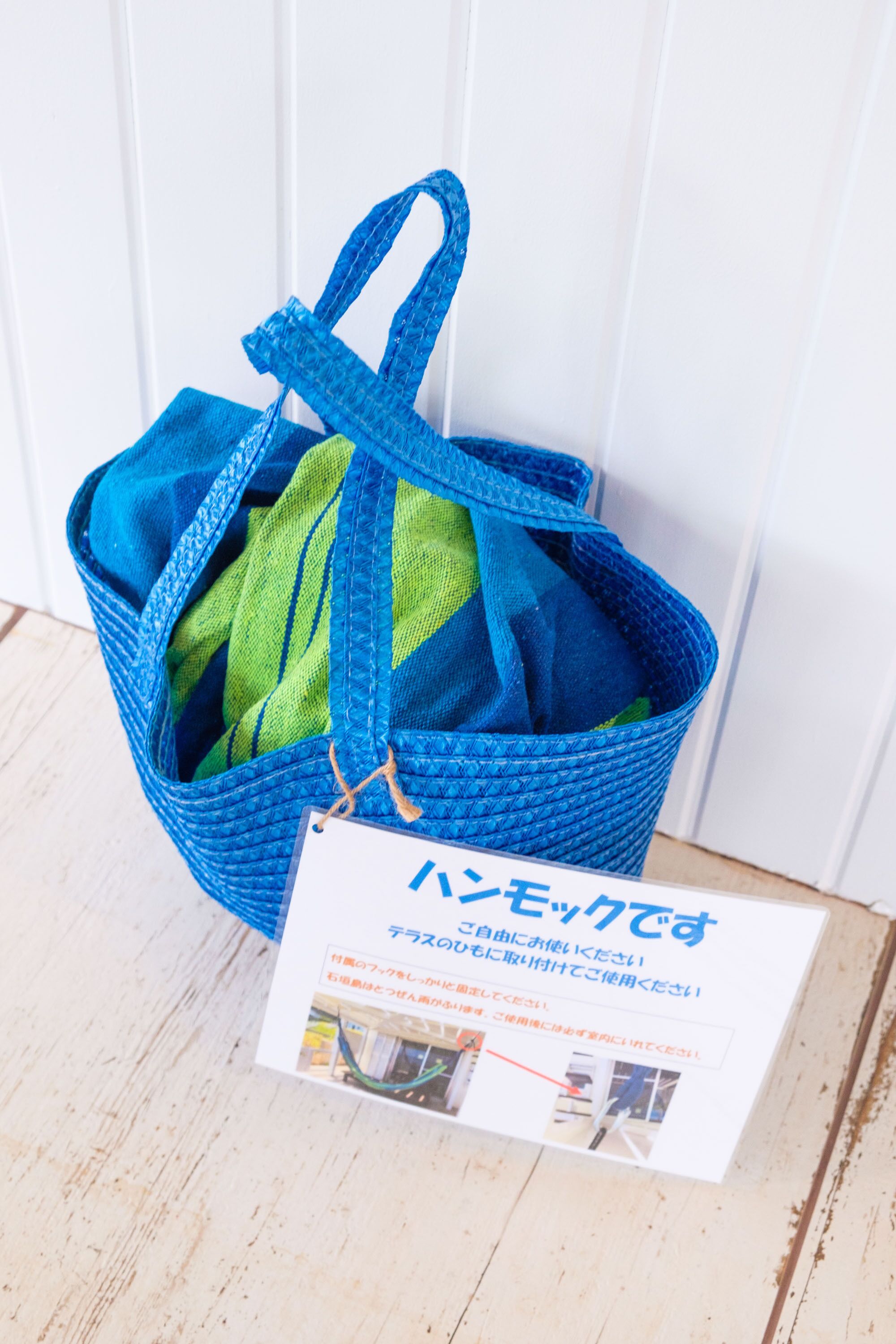 A blue woven bag with a tag.