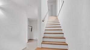 A staircase with wooden steps and white walls.