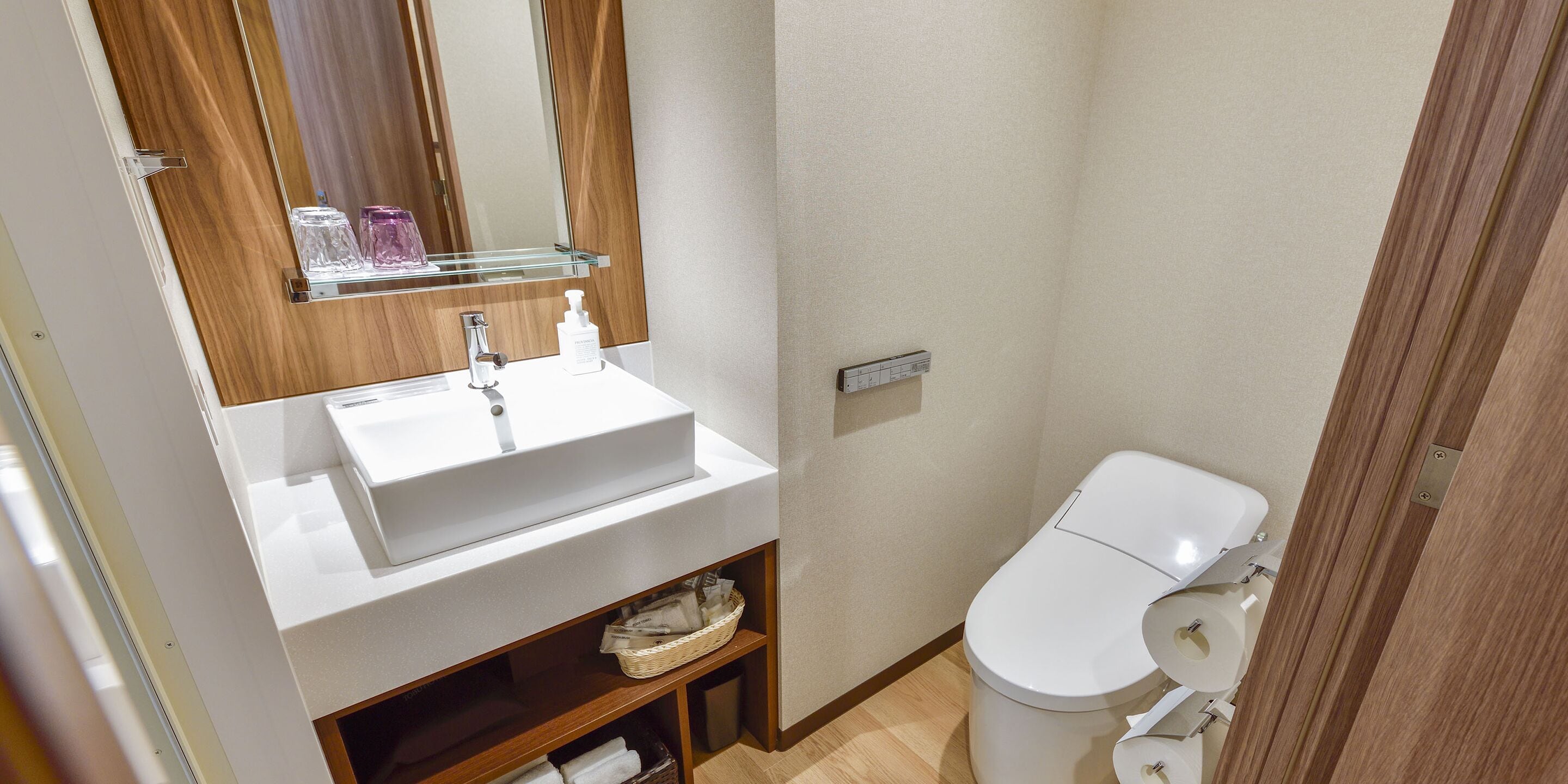 Une salle de bain moderne avec un lavabo blanc, un miroir et des toilettes.