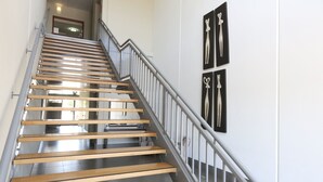 A staircase with wooden steps and metal railings, leading to a landing area with a door.