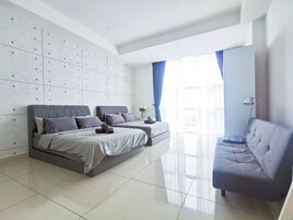 Un dormitorio moderno con una cama grande, un sofá y un mueble de almacenamiento empotrado.