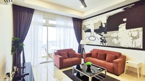A modern living room with two sofas, a coffee table, and a large abstract painting. - KSL D’Esplanade by Antlerzone (Johor Bahru)