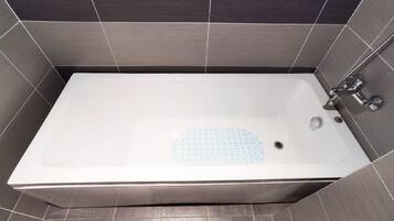 Une baignoire rectangulaire dotée d’un siège intégré, d’un robinet et d’un drain.