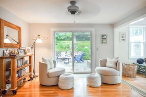 A cozy living room with a fireplace, comfortable seating, and a view of the outdoors.