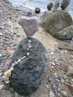 Una playa rocosa con grandes rocas y piedras más pequeñas.