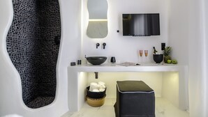 A modern bathroom with a unique design, including a leopard print wall, a large mirror, a black sink, and a flat-screen TV mounted above the counter. - Two Bedroom Apartment, Diadema Apartments Naxos (Naxos)