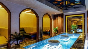 Un moderno vestíbulo de hotel con un mostrador de recepción alargado, zonas de estar cómodas y una fuente central.
