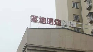 A hotel building with multiple floors, a sign indicating a room for rent, and a digital display. - Su Tang Hotel (Changsha)