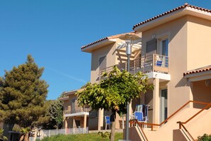 Un bâtiment à deux étages doté de balcons, d’un escalier et surplombant un ciel dégagé.