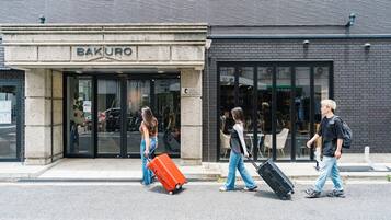 A building with a storefront labeled 'BAKURO' and a sidewalk in front.