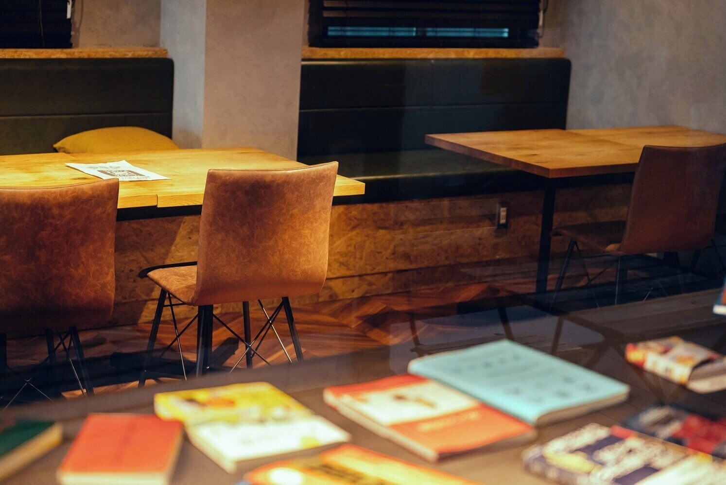 A cozy reading nook with leather chairs, a wooden table, and books.
