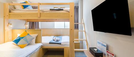 A bunk bed room with a desk, a TV, and a no-smoking sign.