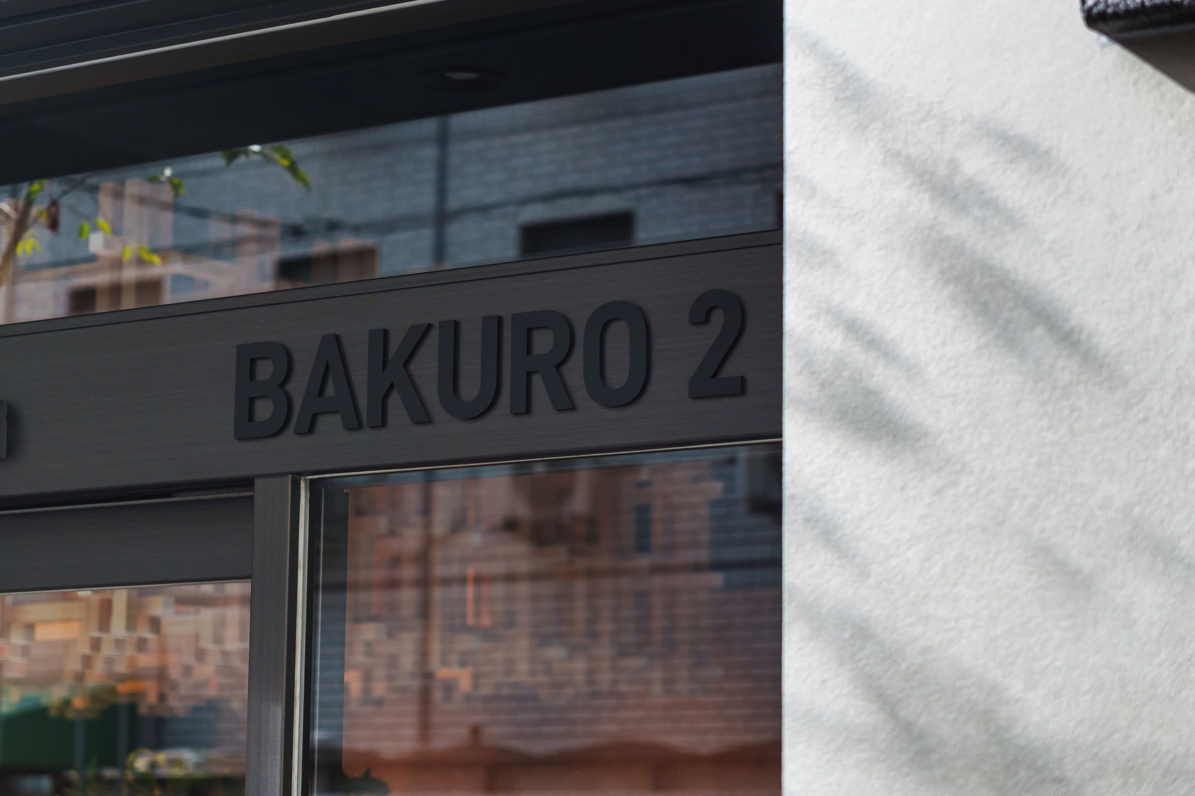 Un letrero de edificio que indica 'BAKURO 2', posiblemente el nombre o la dirección.