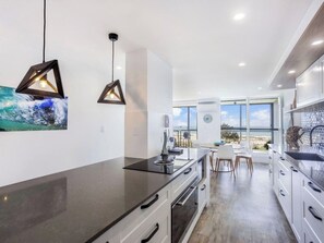 Enjoy a meal with a view of the beach from this kitchen's dining area, which features an oven and sink.