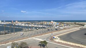A marina with boats docked, a parking area, and a road leading to the beach. - Apartment in Le Lotus Blanc with Sea View (Le Barcares)