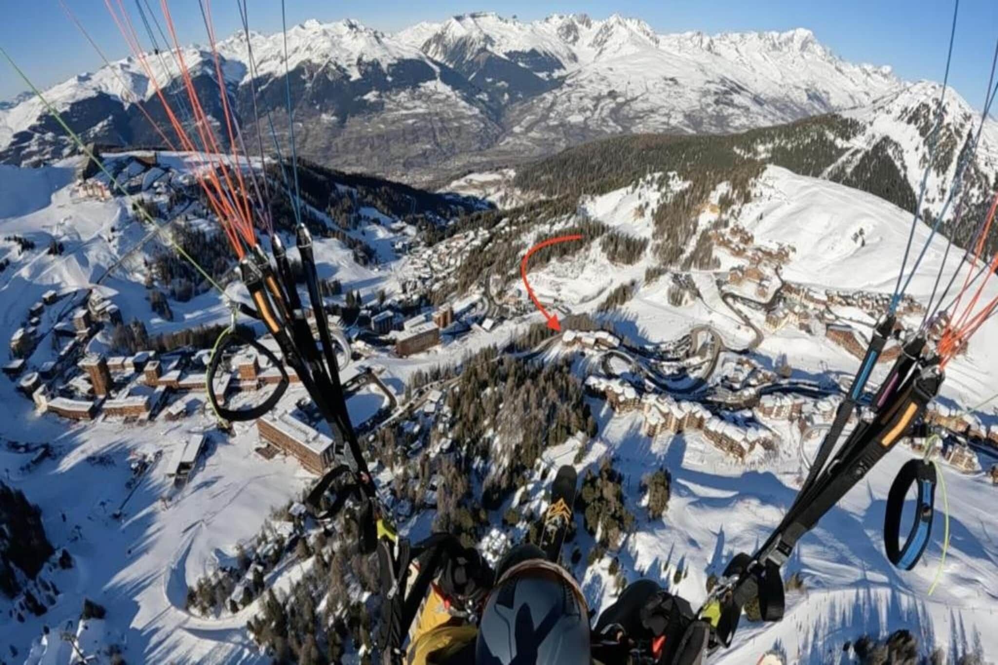 A mountainous landscape with a ski resort, including ski lifts and buildings.
