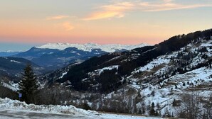 A snow-covered mountain landscape with a winding road. - Apartment by Table Verte Lift (Les allues)