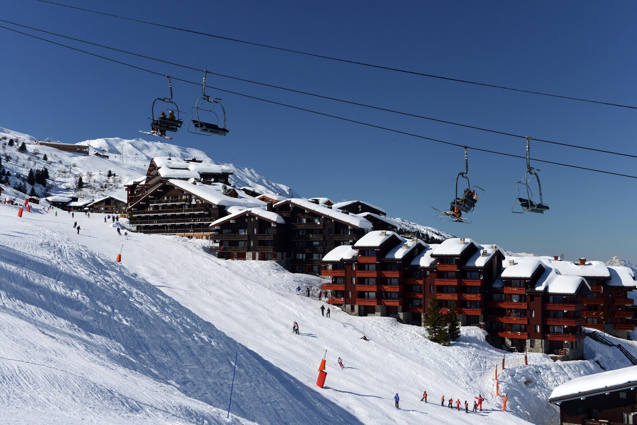 A ski resort with multiple buildings, ski lifts, and skiers on the slopes.