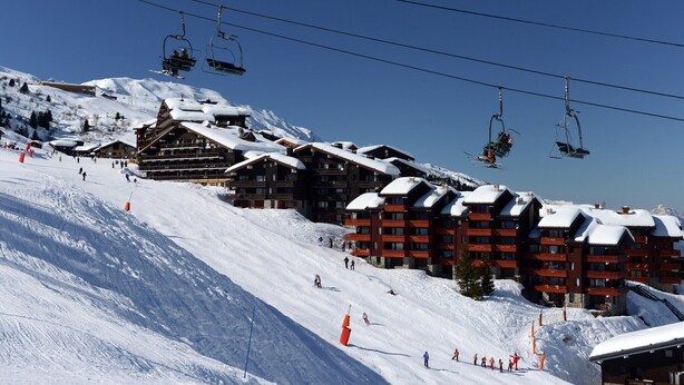 A ski resort with multiple buildings, ski lifts, and skiers on the slopes. - Apartment by Table Verte Lift (Les allues)