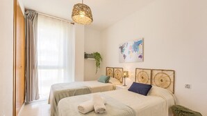 A hotel room with two beds, a large window with curtains, a world map on the wall, and a small stool. - Anacasa Zurich Les Marines AP3216 (Denia)
