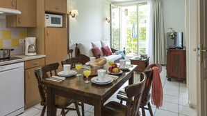 Ein Essbereich mit einem für das Frühstück gedeckten Tisch, einer Mikrowelle und einer Kaffeemaschine in der Küche.