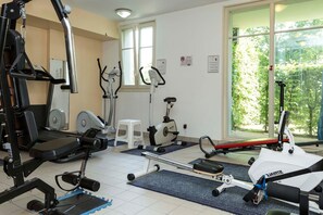 A gym with various exercise equipment, including treadmills, stationary bikes, and weight machines.