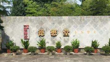 A building facade with Chinese characters and potted plants.