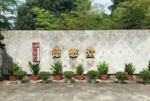 Fachada de edifício com caracteres chineses e plantas em vasos.