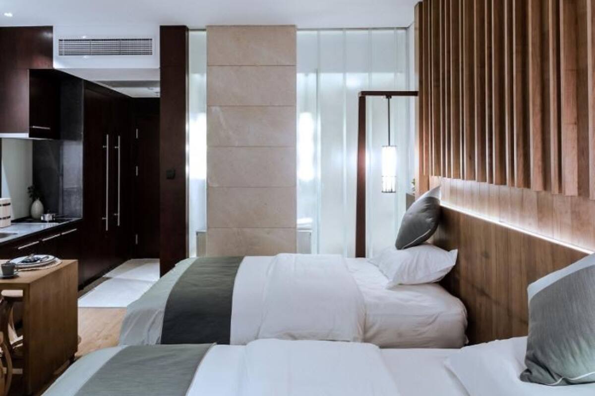Une chambre d’hôtel moderne, dotée d’un grand lit, d’un bureau et d’une armoire.