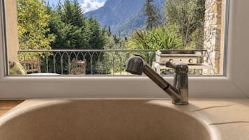 Un baño con lavamanos, ventana y vistas a las montañas.