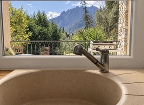 Une salle de bain avec un lavabo, une fenêtre et une vue sur les montagnes.
