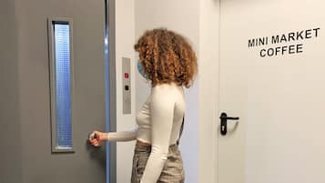 Una mujer entrando por una puerta con la leyenda 'MINI MARKET COFFEE'.