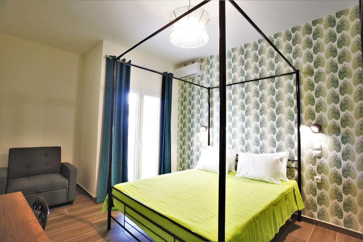 Une chambre avec un lit à baldaquin, un canapé et une table à manger.