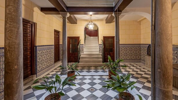 A grand hallway with a checkered floor, ornate columns, and a staircase leading to an upper level. - Mirador San Jeronimo-Cathedral CTH Granada (Granada)
