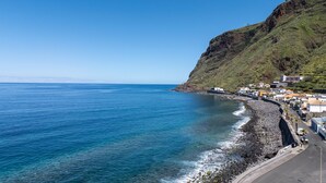 Une ville côtière avec un littoral rocheux, des bâtiments le long de la côte et une vue dégagée sur la mer.