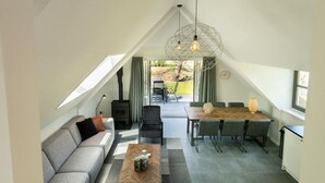 Un espace de vie moderne de style loft, comprenant un coin repas, un canapé, une table basse et une cheminée.