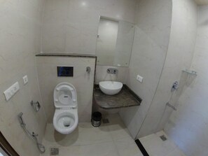 Un baño pequeño y moderno con inodoro, lavamanos y ducha.