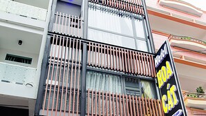 Entrada de hotel con diseño moderno, que incluye una escalera que lleva a los pisos superiores, un mostrador de recepción y una escalera con número visible.