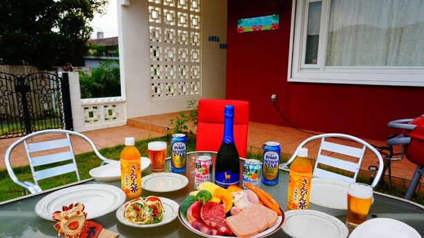 Een buitentafel met borden eten, drinken en een decoratief object.