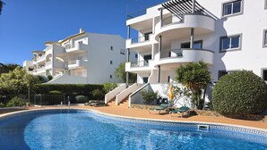 En pool med ett geometriskt mönster av kakel, omgiven av en kakelbeklädd poolterrass.