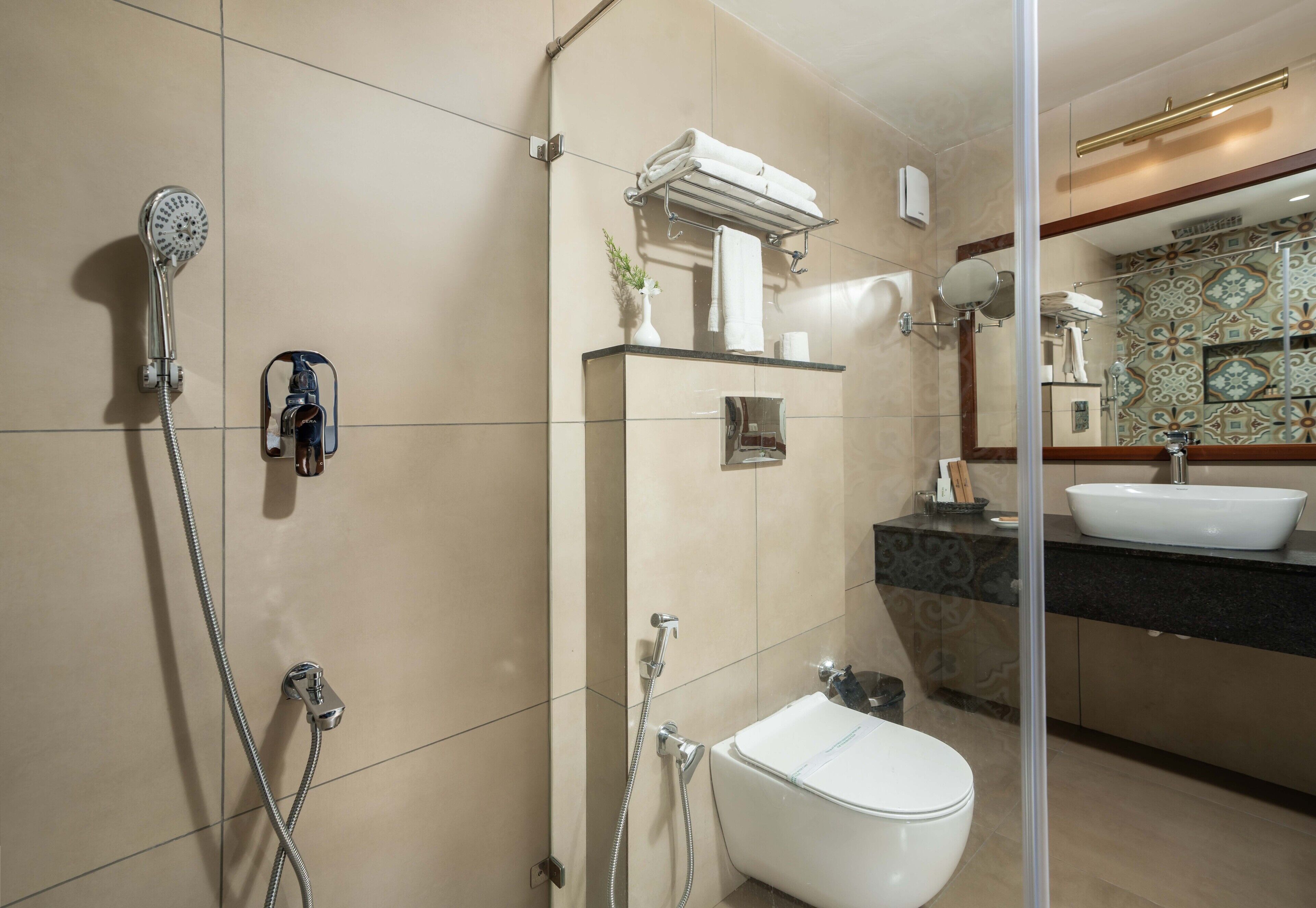 A modern bathroom with a shower, toilet, and sink.