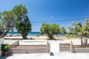 A coastal property with a paved entrance, a gate, and a view of the sea.