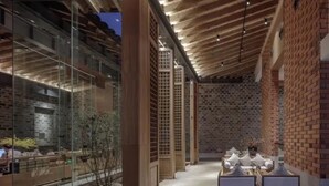 Un intérieur moderne avec une façade en verre, des poutres en bois et des murs en briques.