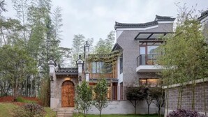 Un bâtiment de style traditionnel, doté d’une porte en bois, d’une arche en pierre et d’un mur en briques.